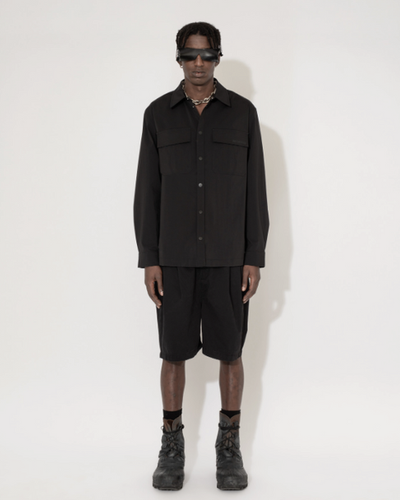 A man wearing a Han Kjøbenhavn black shirt and shorts