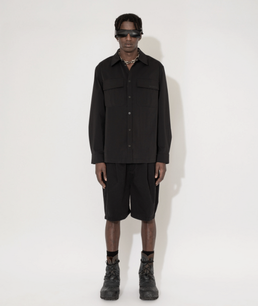 A man wearing a Han Kjøbenhavn black shirt and shorts