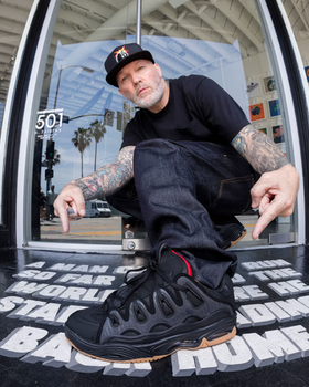 A man close up of a man wearing Osiris skateshoes in black and red