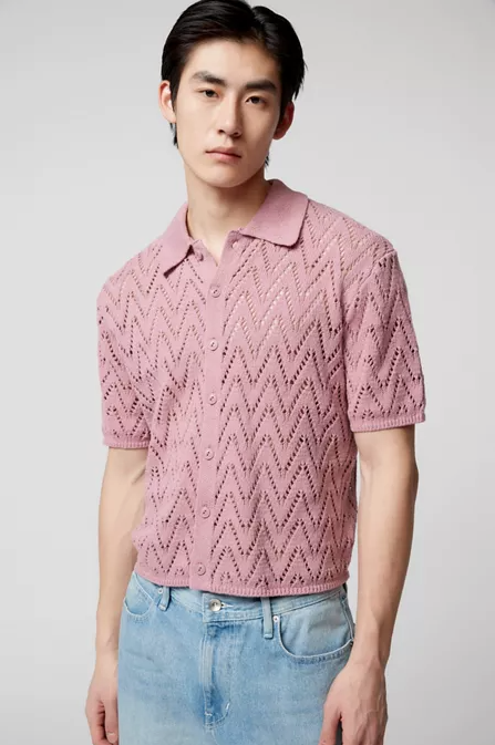 A man wearing a trendy Urban Outfitters pink collared shirt and denim pants