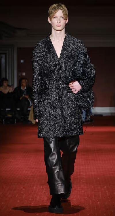 A man wearing a Simone Rocha black outfit with leather pants