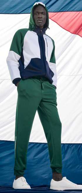 A man wearing a Nautica outfit featuring the logo and green pants