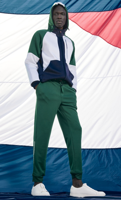 A man wearing a Nautica outfit featuring the logo and green pants