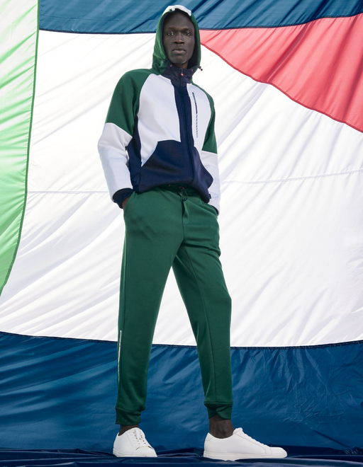 A man wearing a Nautica outfit featuring the logo and green pants
