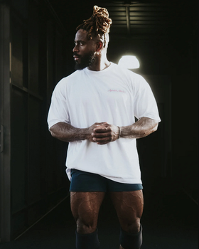 A man wearing a Alphalete white t-shirt with short shorts