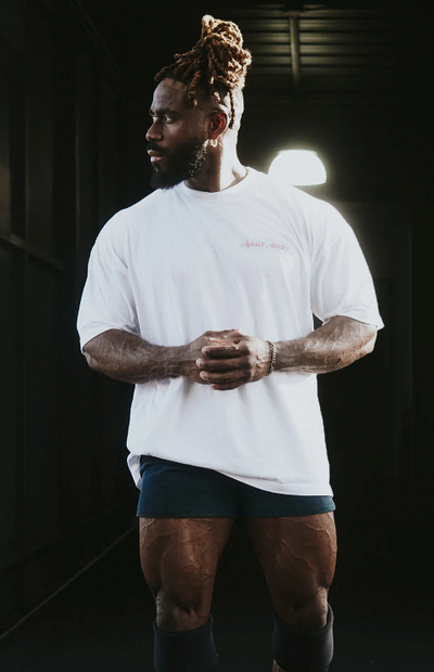 A man wearing a Alphalete white t-shirt with short shorts