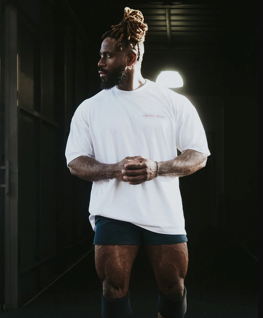 A man wearing a Alphalete white t-shirt with short shorts