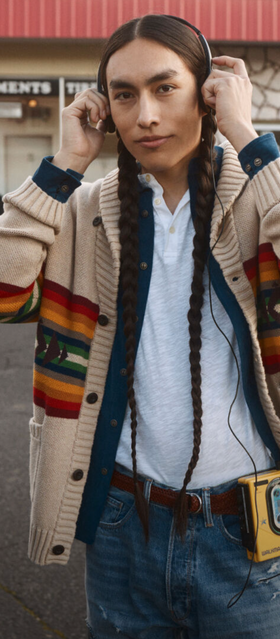 A man wearing a Pendleton brown sweater with jeans