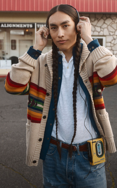 A man wearing a Pendleton brown sweater with jeans