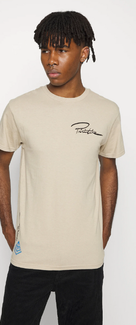 A man wearing a branded logo Primitive beige t-shirt and black pants