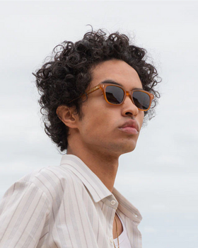 A man wearing a pair of ollie quinn brown sunglasses