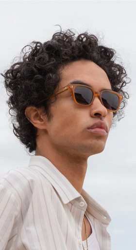 A man wearing a pair of ollie quinn brown sunglasses