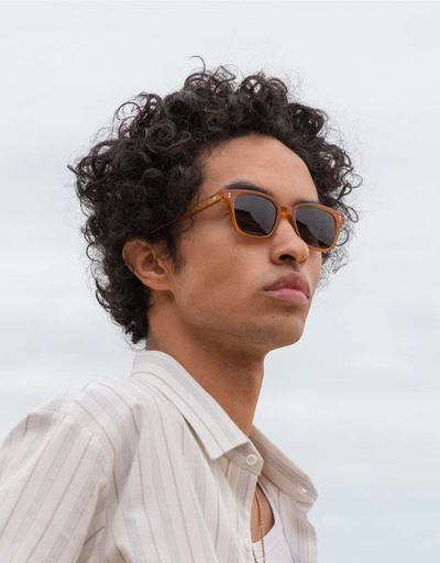 A man wearing a pair of ollie quinn brown sunglasses