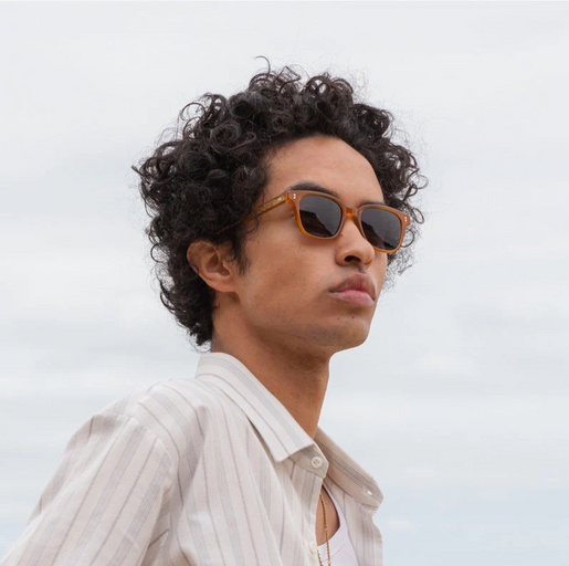 A man wearing a pair of ollie quinn brown sunglasses