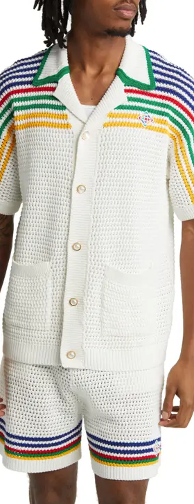 A man wearing a white striped Casablanca button up with matching shorts