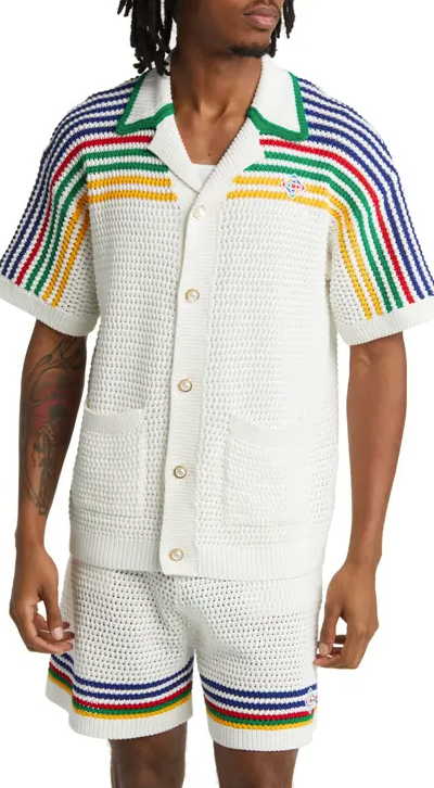 A man wearing a white striped Casablanca button up with matching shorts