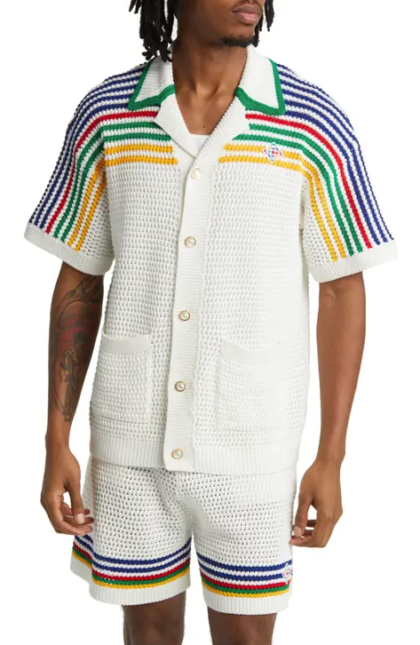 A man wearing a white striped Casablanca button up with matching shorts