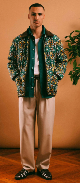 A man wearing a Drôle de Monsieur outfit featuring a floral jacket and khaki pants