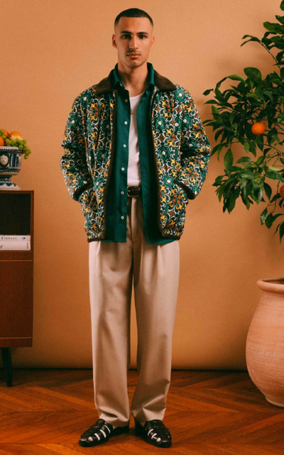 A man wearing a Drôle de Monsieur outfit featuring a floral jacket and khaki pants