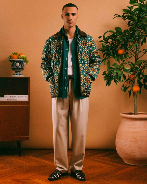 A man wearing a Drôle de Monsieur outfit featuring a floral jacket and khaki pants