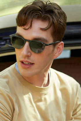 A man wearing a pair of krewe sunglasses while wearing a yellow shirt