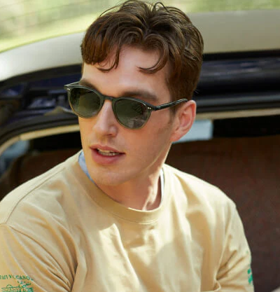 A man wearing a pair of krewe sunglasses while wearing a yellow shirt