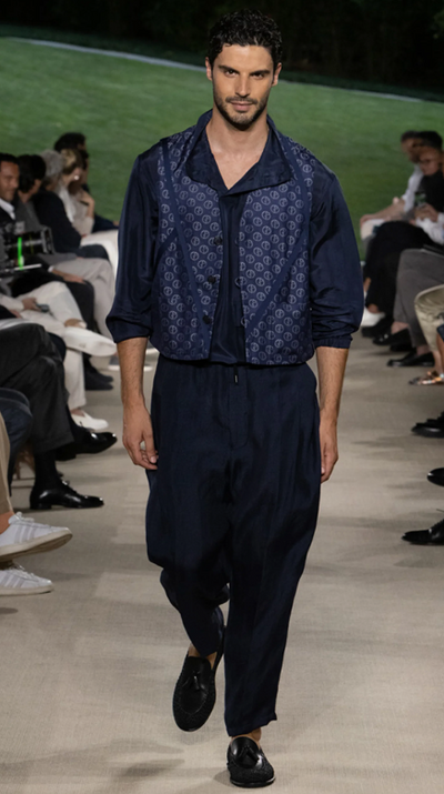 A man wearing a Giorgio Armani outfit walking a runway