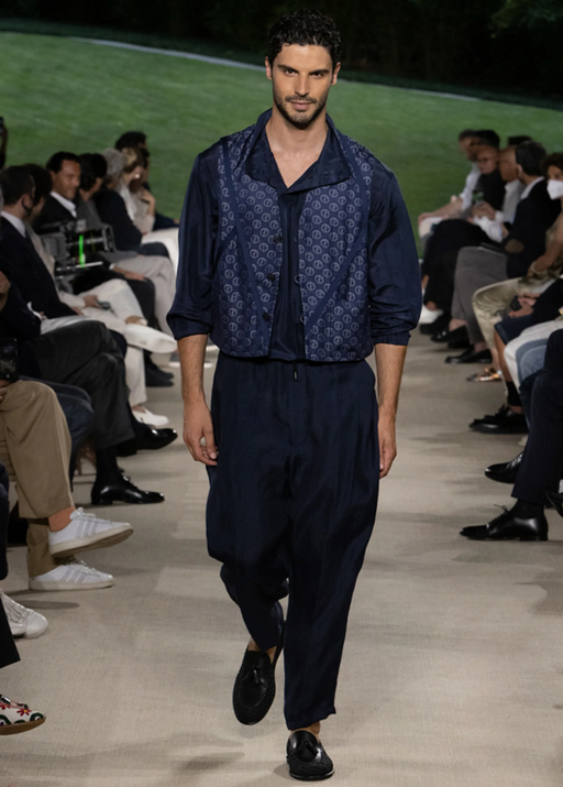 A man wearing a Giorgio Armani outfit walking a runway