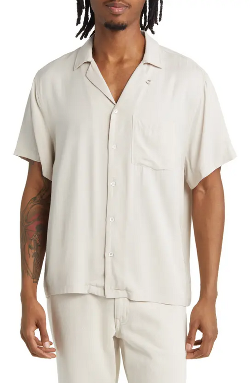 A man wearing an Elwood cream short-sleeve and matching pants