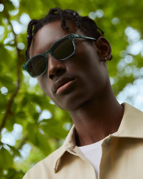 a man wearing a Warby Parker green sunglasses