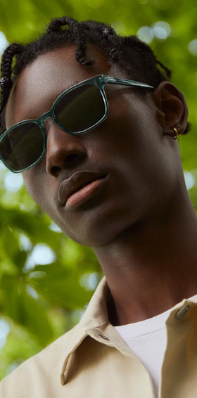 a man wearing a Warby Parker green sunglasses
