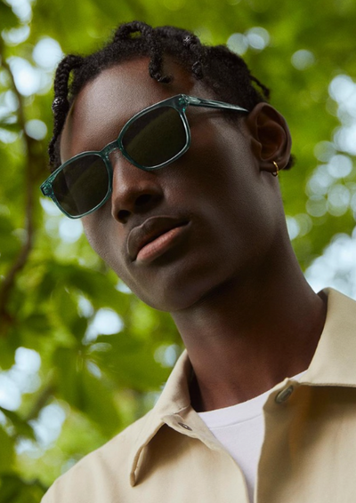 a man wearing a Warby Parker green sunglasses