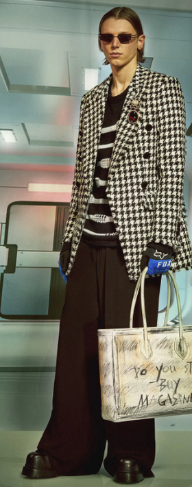 A man wearing a Balmain outfit with a checkered suit jacket and wide pants