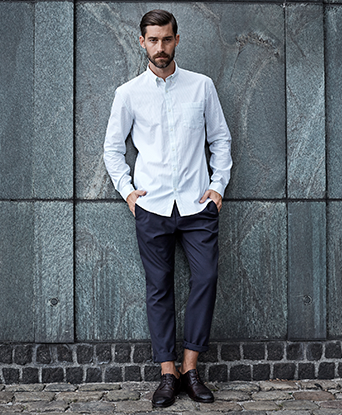 A man wearing a white button up and dress slacks by Selected Homme
