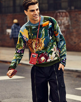 A man wearing a Dolce & Gabbana outfit featuring a tiger print sweater