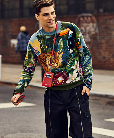 A man wearing a Dolce & Gabbana outfit featuring a tiger print sweater