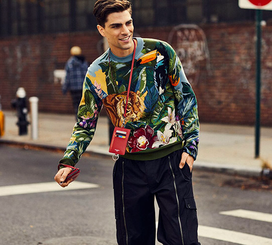 A man wearing a Dolce & Gabbana outfit featuring a tiger print sweater