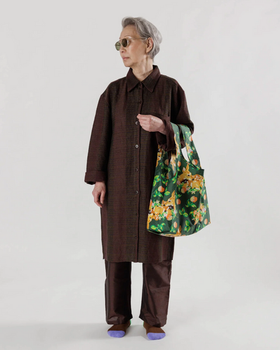 A woman wearing a brown outfit featuring a colorful green baggu bag