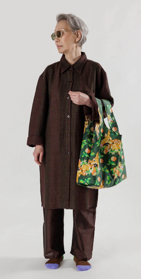 A woman wearing a brown outfit featuring a colorful green baggu bag