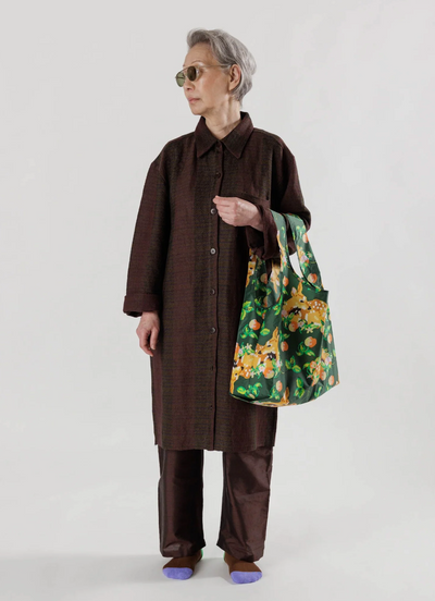A woman wearing a brown outfit featuring a colorful green baggu bag