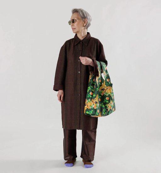 A woman wearing a brown outfit featuring a colorful green baggu bag