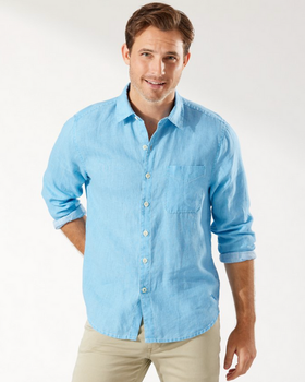 A man wearing a light blue Tommy Bahama button up shirt with khaki pants