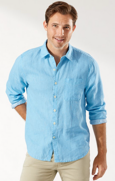 A man wearing a light blue Tommy Bahama button up shirt with khaki pants