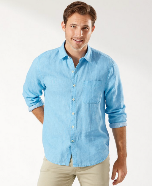 A man wearing a light blue Tommy Bahama button up shirt with khaki pants