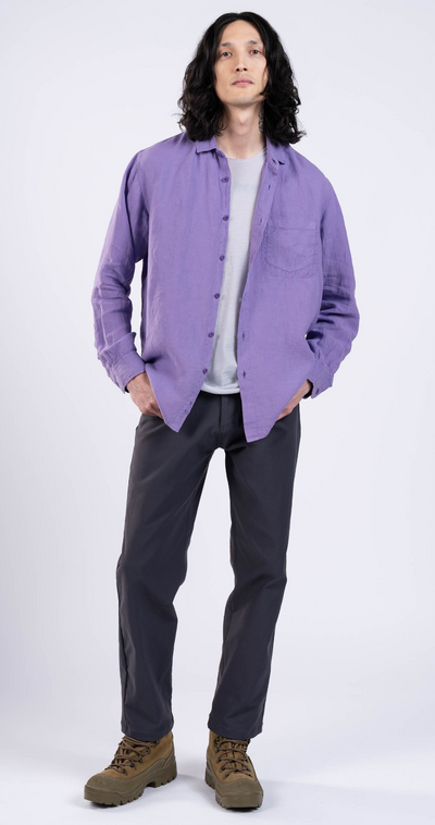 A man wearing a purple Outlier NYC button up shirt and black pants