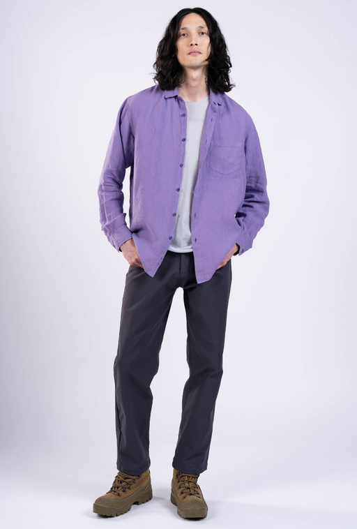 A man wearing a purple Outlier NYC button up shirt and black pants