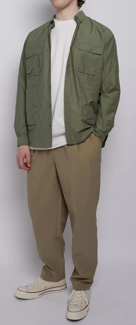 A man wearing a Nigel Cabourn outfit featuring a green light jacket and brownish green pants