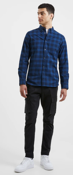 A man wearing a checkered plaid French Connection blue button up with black pants