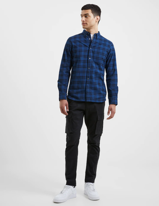 A man wearing a checkered plaid French Connection blue button up with black pants