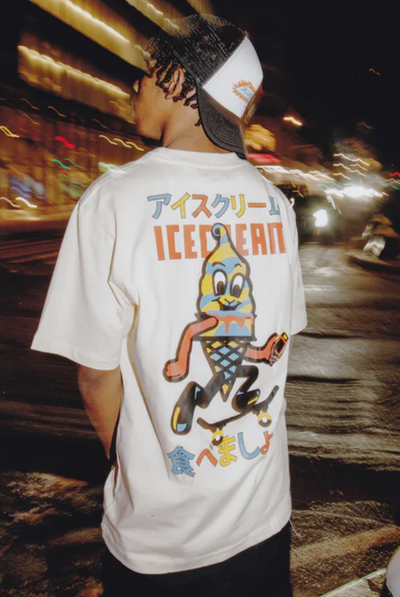 A man wearing an Ice Cream / Billionaire Boys Club white t-shirt with a graphic-forward colors